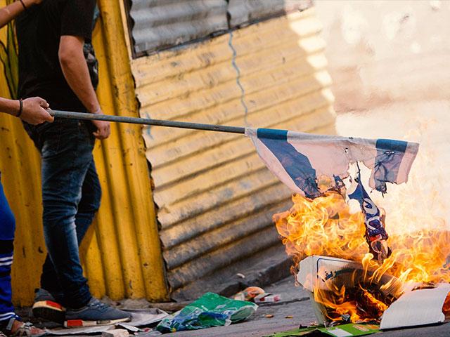 Palestinians burn Israeli flag