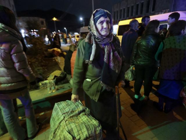 An ethnic Armenian woman from Nagorno-Karabakh carries her suitcase to a tent camp after arriving to Armenia's Goris in Syunik region, Armenia, Sept. 29, 2023. (AP Photo/Vasily Krestyaninov)