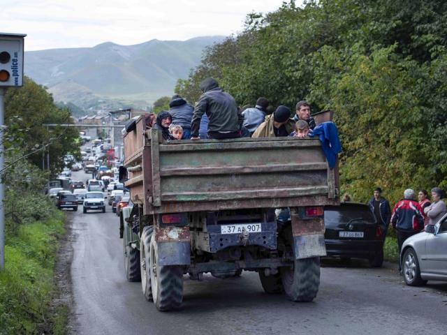 Ethnic Armenians from Nagorno-Karabakh sit in a truck on their way to Goris in Syunik region, Armenia, on Tuesday, Sept. 26, 2023. (AP Photo/Gayane Yenokyan)