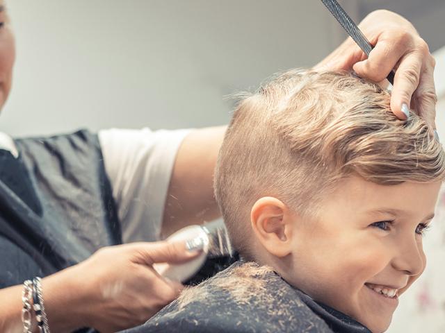 boy getting a buzz haircut at the salon