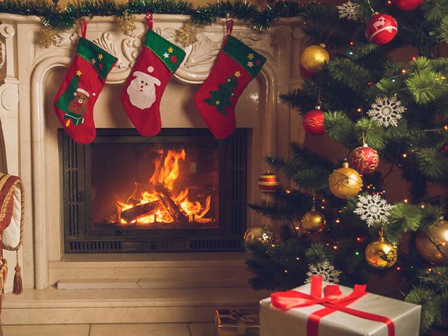 christmas stockings hanging above a fireplace next to a christmas tree