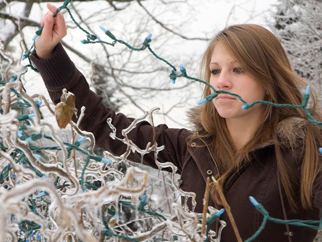 woman untangling exterior christmas lights