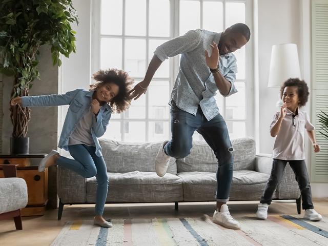 two children dancing with their father