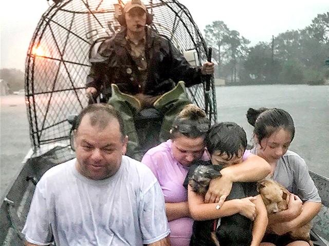 A family is rescued via fan boat by from the flood waters of Tropical Depression Imelda near Beaumont, Texas, Sept. 19, 2019. (Texas Parks &amp; Wildlife Department via AP)