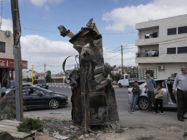 Palestinians inspect the debris of an Iranian missile intercepted by Israel, in the West Bank city of Hebron, Oct. 2, 2024. (AP Photo/Mahmoud Illean)