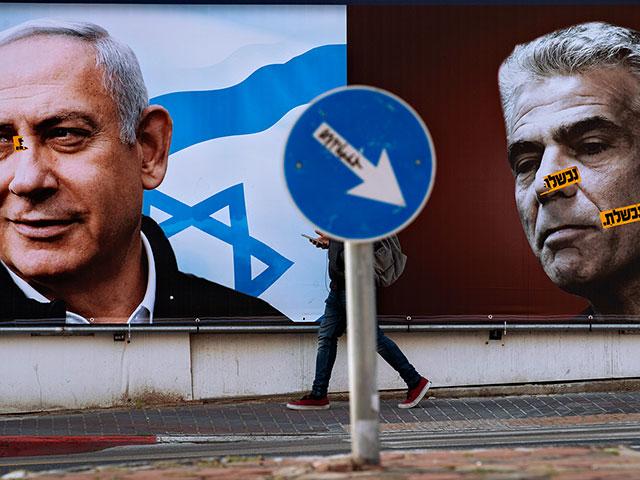 An election campaign billboard for the Likud party shows a portrait of its leader Prime Minister Benjamin Netanyahu, left, and opposition party leader Yair Lapid.  (AP Photo/Oded Balilty)