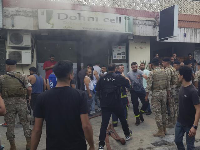 PHOTO Lebanese soldiers and firefighters gather outside a mobile shop after what is believed to be the result of a walkie-talkie exploding inside it, in Sidon, Lebanon, Sept. 18, 2024. (AP Photo/Mohammed Zaatari)