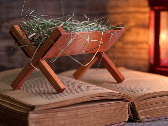 a manger sits on top of a Bible