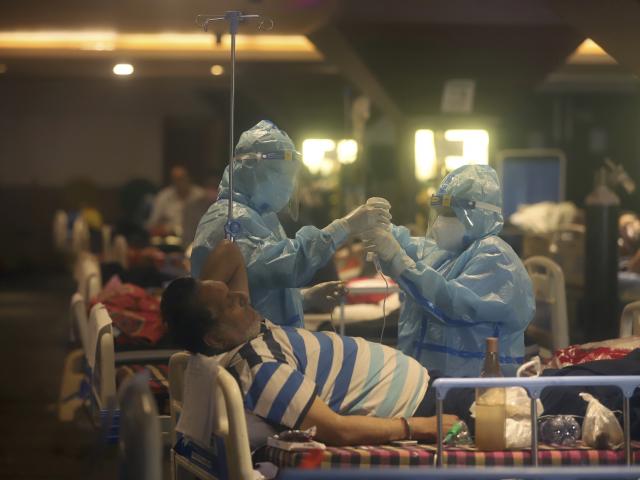 Health workers attend to COVID-19 patients at a makeshift hospital in New Delhi, India, Friday, April 30,
