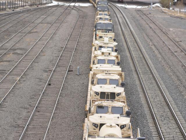 Military vehicles loaded on flatbed rail cars are pulled by Burlington Northern locomotives Wednesday, Nov. 23, 2022, in Colorado Springs, Colo. (AP Photo/David Zalubowski)
