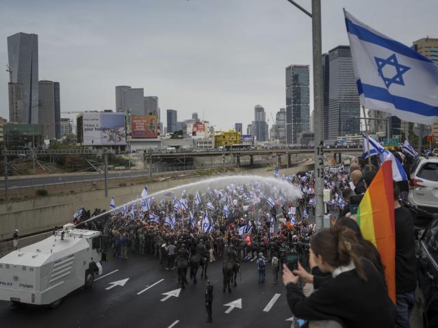 Israeli police use a water cannon to disperse Israelis blocking the freeway during a protest against plans by Prime Minister Benjamin Netanyahu&#039;s government to overhaul the judicial system in Tel Aviv, Thursday, March 23, 2023. (AP Photo/Oded Balilty)