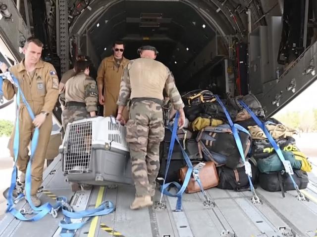 In this image from video provided by the French Armed Forces, military personnel load belongings of evacuees onto a plane at the airport in Khartoum, Sudan, on Sunday, April 23, 2023. (French Armed Forces via AP)