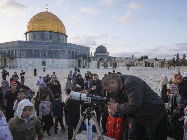 A man observes the moon through a telescope next to the Dome of Rock Mosque at the Al-Aqsa Mosque compound in Jerusalem&#039;s Old City, Sunday, March 10, 2024. (AP Photo/Mahmoud Illean) 