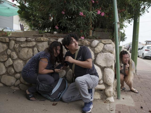  Israelis take cover from the incoming rocket fire from the Gaza Strip in Ashkelon, southern Israel on Oct. 11, 2023. (AP Photo/Leo Correa, File)