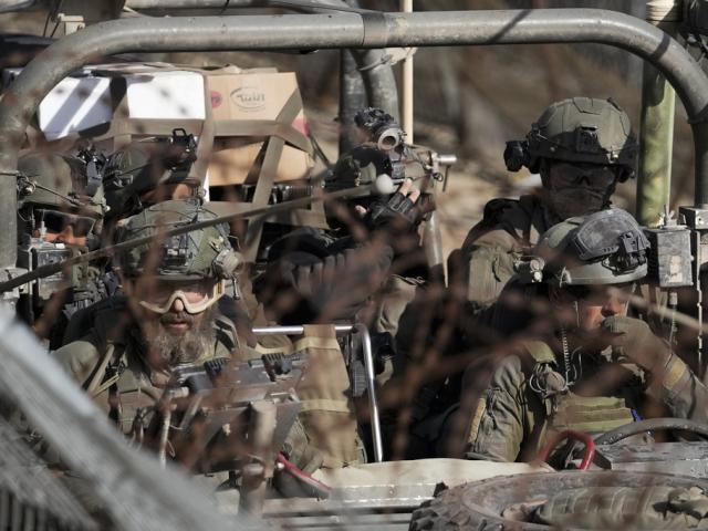 Israeli soldiers stand on an armoured vehicle before crossing the security fence, moving towards the so-called Alpha Line that separates the Golan Heights from Syria, in the town of Majdal Shams, Dec. 11, 2024. (AP Photo/Matias Delacroix)