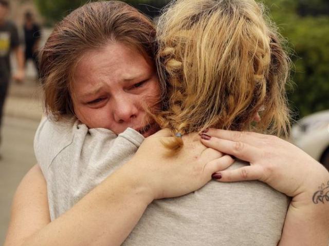 Carla Bledsoe, facing camera, hugs her sister Sherri outside of the sheriff’s office after hearing news that Sherri’s children James, 4, and Emily 5, and grandmother were killed in a wildfire Saturday, July 28, 2018, in Redding, Calif.