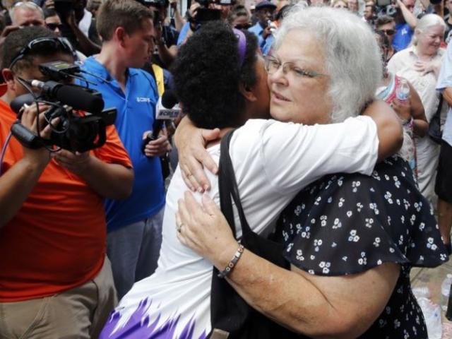 Susan Bro, mother of Heather Heyer who was killed during last year’s Unite the Right rally, embraces supporters after laying flowers at the spot her daughter was killed in Charlottesville, Va.