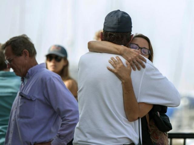People hug each other as they await news outside of the Truth Aquatics office in Santa Barbara, Calif., on Monday, Sept. 2, 2019. (AP Photo/Christian Monterrosa)