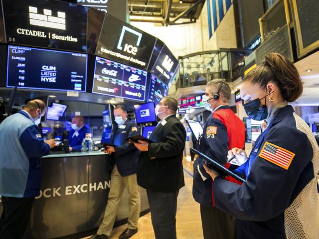 In this photo provided by the New York Stock Exchange, trader Samantha Tavares, right, works with colleagues on the floor, Wednesday, Jan. 27, 2021. (Courtney Crow/New York Stock Exchange via AP) nystockexange