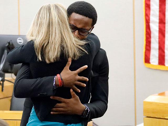 Botham Jean&#039;s younger brother Brandt Jean hugs convicted murderer Amber Guyger after delivering his impact statement to her after she was sentenced to 10 years in jail, Oct. 2, 2019. (Tom Fox/The Dallas Morning News via AP)