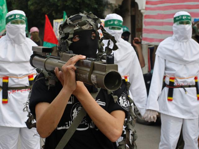 A masked Palestinian Hamas member holds a weapon during a demonstration to show solidarity with Sudan, in the Bureij refugee camp, central Gaza Strip, Friday, March 6, 2009. (AP Photo/Hatem Moussa)