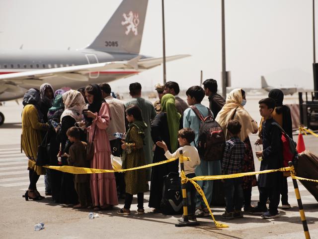 In this photo provided by the U.S. Marine Corps, civilians prepare to board a plane during an evacuation at Hamid Karzai International Airport, Kabul, Afghanistan, Wednesday, Aug. 18, 2021. (Staff Sgt. Victor Mancilla/U.S. Marine Corps via AP)