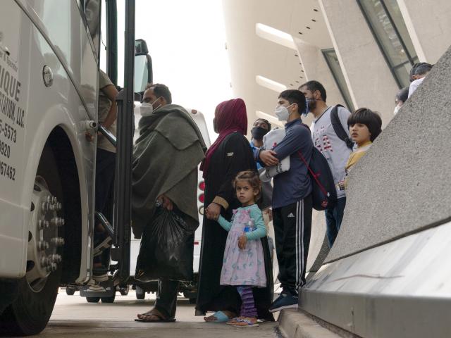 Families evacuated from Kabul, Afghanistan, wait to board a bus after they arrived at Washington Dulles International Airport, in Chantilly, Va., on Thursday, Aug. 26, 2021. (AP Photo/Jose Luis Magana)