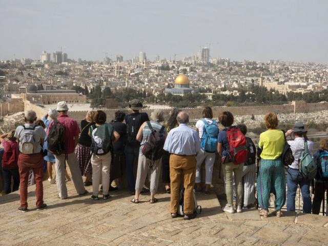 French tourists look at the Temple Mount compound from the Mount of Olives in Jerusalem, Monday, Nov. 1, 2021.  (AP Photo/Sebastian Scheiner)a