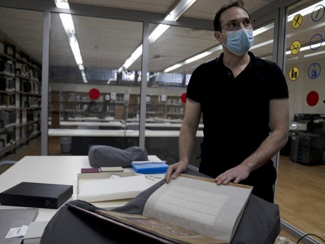 Sam Thrope displays an Arabic book that is part of the collection of the National Library of Israel, on The Hebrew University campus in Jerusalem, Thursday, Jan. 6, 2022.  (AP Photo/Maya Alleruzzo)
