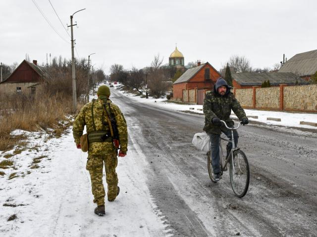 A Ukrainian serviceman patrols a street near the frontline with Russia-backed separatists in Verkhnotoretske village in Yasynuvata district, Donetsk region, eastern Ukraine, Jan. 22, 2022. (AP Photo)