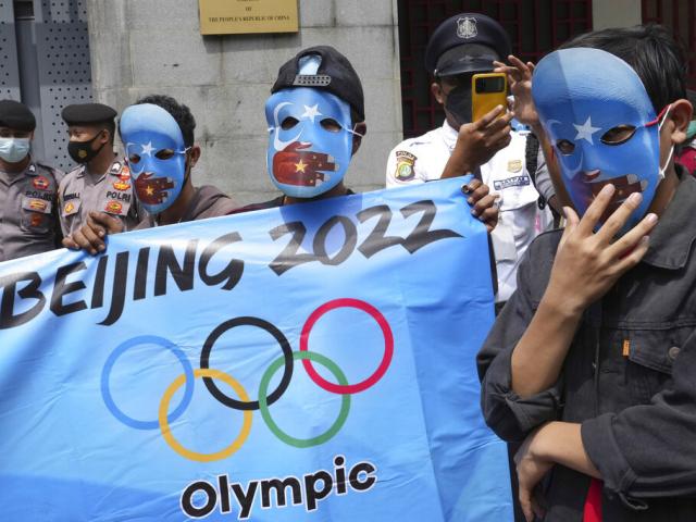 Student activists wear masks with the colors of the pro-independence East Turkistan flag during a rally to protest the Beijing 2022 Winter Olympic Games, outside the Chinese Embassy in Jakarta, Indonesia, Friday, Jan. 14, 2022. AP Photo. 