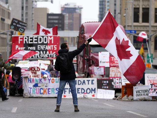 A protester waves a Canadian flag in Ottawa, Ontario, Friday, Feb. 11, 2022. (Justin Tang/The Canadian Press via AP)
