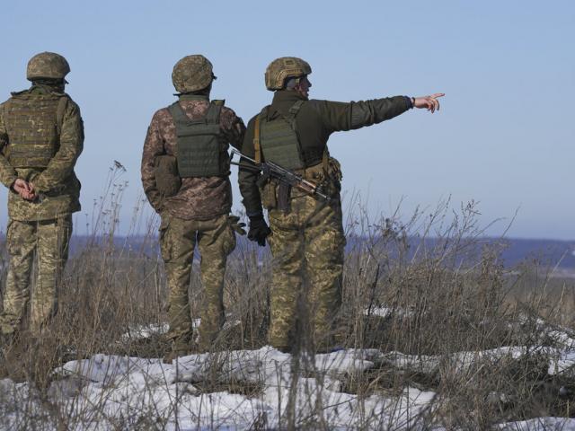 Ukrainian servicemen survey the impact areas from shells that landed close to their positions during the night on a front line outside Popasna, Luhansk region, eastern Ukraine, Monday, Feb. 14, 2022. (AP Photo/Vadim Ghirda)