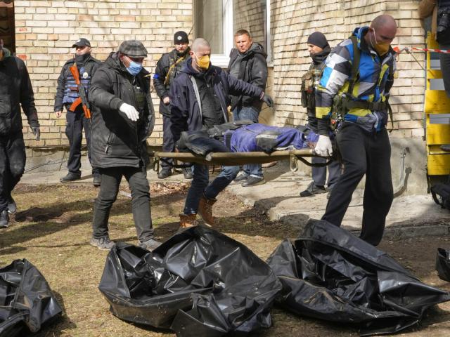Volunteers collect bodies of murdered civilians, in Bucha, close to Kyiv, Ukraine, Monday, April 4, 2022. (AP Photo)