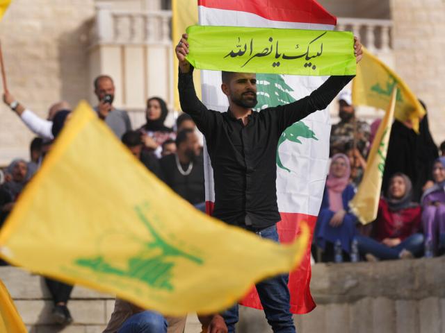 A Hezbollah supporter holds up an Arabic banner that reads: &quot;At your service Nasrallah,&quot; as he attends an election campaign, in Baalbek, east Lebanon, Friday, May 13, 2022.  (AP Photo/Hussein Malla)