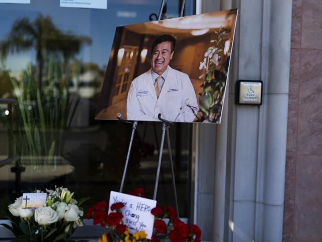 A photo of Dr. John Cheng, a 52-year-old victim who was killed in Sunday&#039;s shooting at Geneva Presbyterian Church, is displayed outside his office in Aliso Viejo, Calif., Monday, May 16, 2022. (AP Photo)