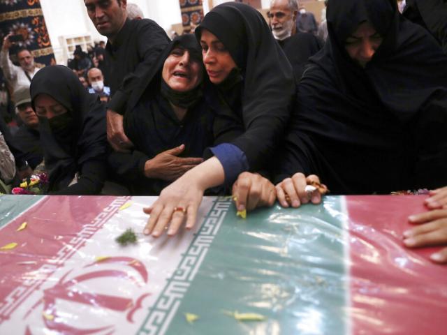 Relatives mourn over the flag draped coffin of Iran&#039;s Revolutionary Guard Col. Hassan Sayyad Khodaei during his funeral ceremony in Tehran, Iran, Tuesday, May 24, 2022. (AP Photo)