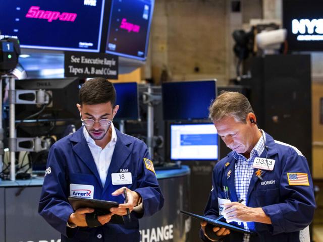 In this photo provided by the New York Stock Exchange, traders Orel Partush, left, and Robert Charmak work on the floor, Friday, June 10, 2022. (David L. Nemec/New York Stock Exchange via AP)