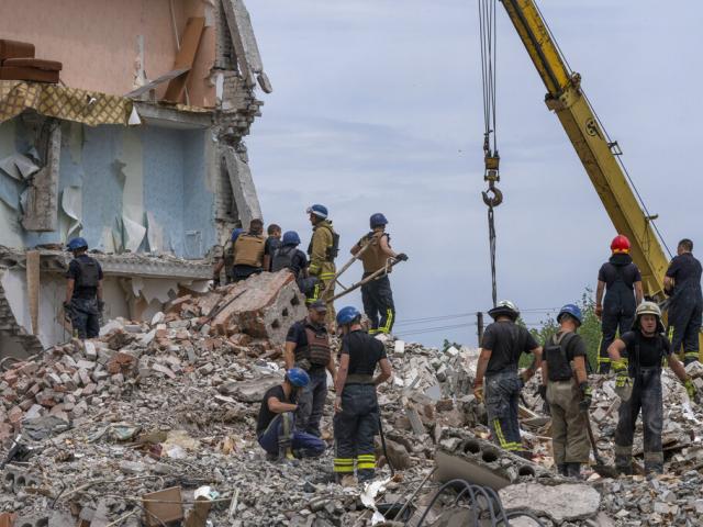 Rescue workers sift through rubble at the scene in the after math of a Russian rocket that hit an apartment residential block, in Chasiv Yar, Donetsk region, eastern Ukraine, Sunday, July 10, 2022. (AP Photo/Nariman El-Mofty)