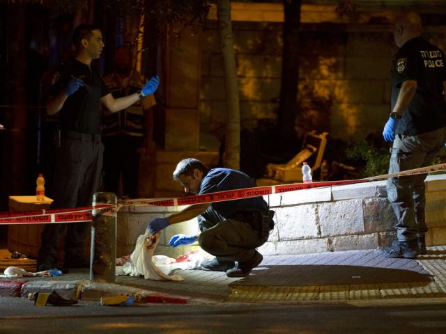 Israeli police crime scene investigators work at the scene of a shooting attack that wounded several Israelis near the Old City of Jerusalem, early Sunday, Aug. 14, 2022. (AP Photo/ Maya Alleruzzo)