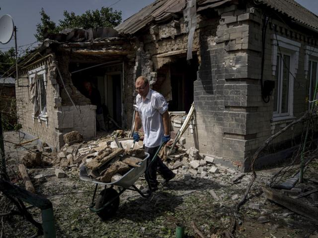Dmyto Shengur cleans rubble in front of the house which was damaged after Russian bombardment of residential area in Nikopol, Ukraine, on Monday, Aug, 22, 2022. (AP Photo)