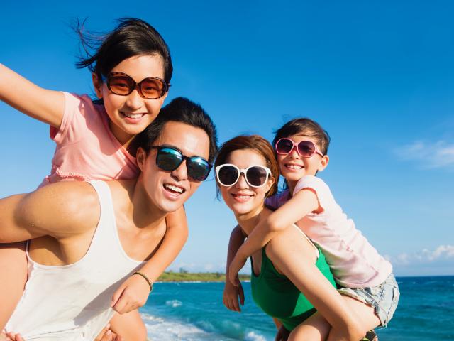 Happy family on beach wearing sunglasses
