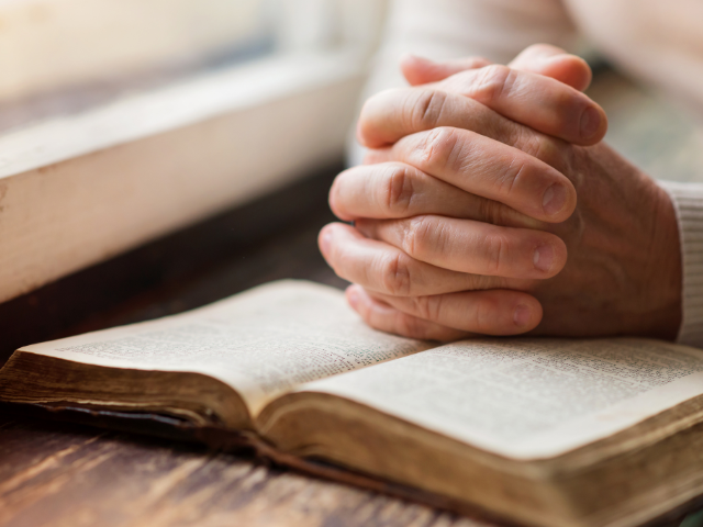 Bible hands praying