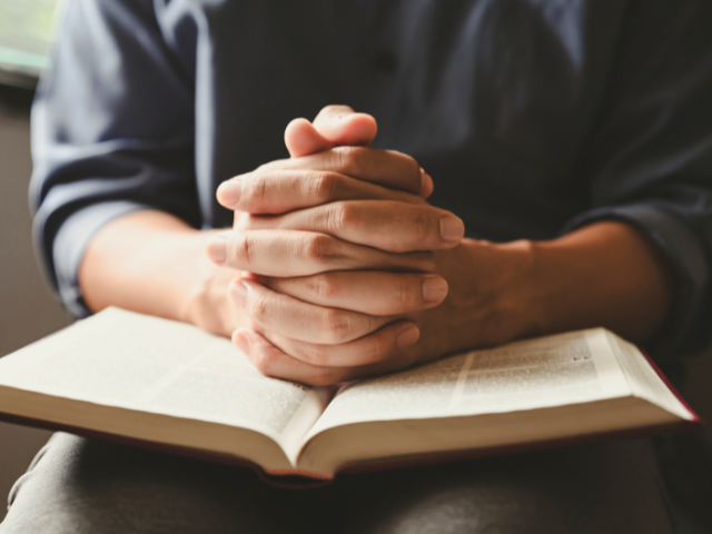 man praying with an open Bible
