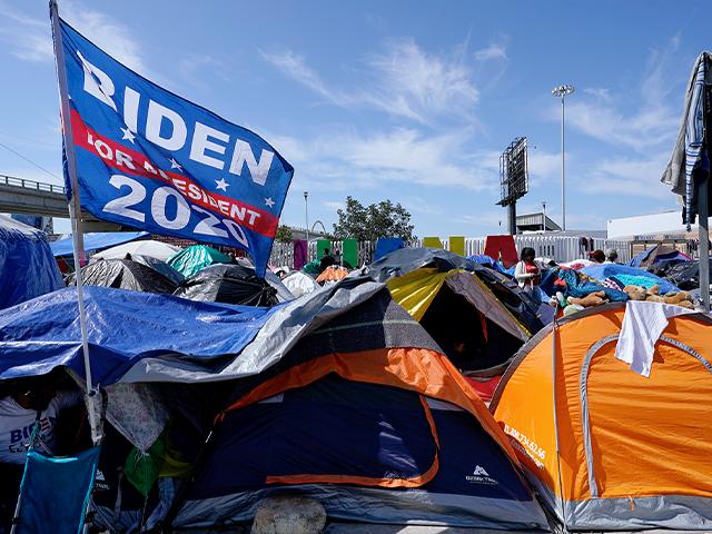 A campaign flag for President Joe Biden flies over tents at a camp of migrants at the border port of entry leading to the U.S., March 17, 2021, in Tijuana, Mexico. (AP Photo/Gregory Bull)