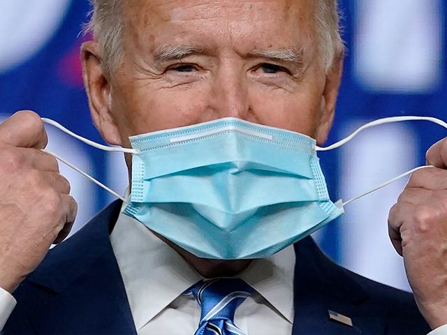 Democratic presidential candidate former Vice President Joe Biden takes off his face mask. (AP Photo/Carolyn Kaster)