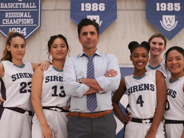 Big Shot movie on Disney+ John Stamos standing with girls basketball team on basketball court