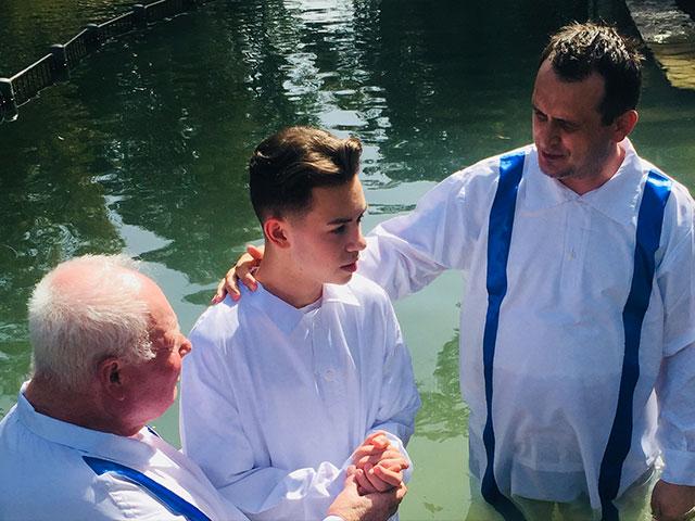 Bishop Doru de Ilioi, right, prepares to baptize Eldad, a young man who asked to be baptized after watching Mario Lopez&#039;s baptism. On the left is Petre Ursu who assisted. Photo courtesy: Bishop Doru de Ilioi.