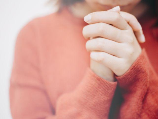 young hands clasped in prayer