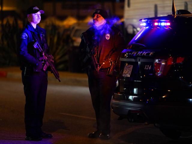 Two police officers stand guard near a scene where a mass shooting took place in Monterey Park, CA, Sunday, Jan. 22, 2023. (AP Photo/Jae C. Hong)